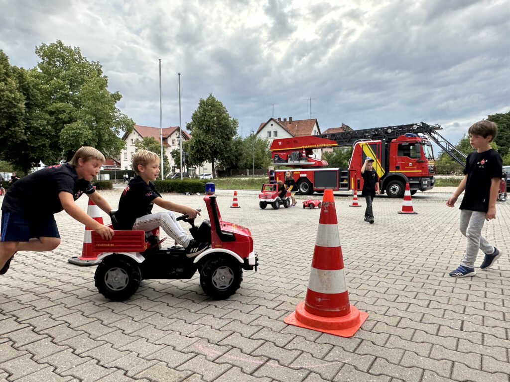 Kinder fahren Feuerwehr-Bobby-Cars